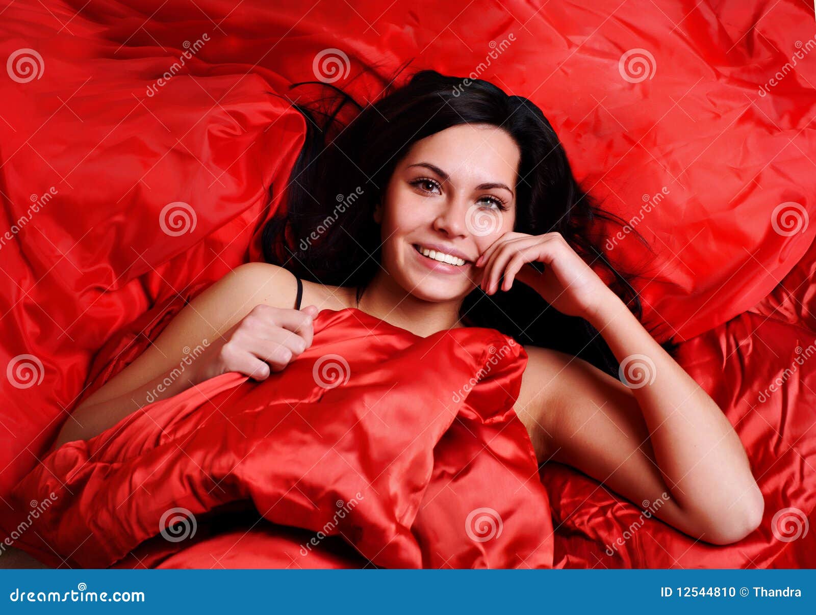 Woman on red silk sheets stock photo. Image of female 12544810