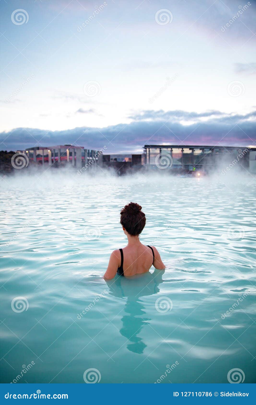 woman relaxes and enjoys of spa in hot spring blue lagoon in ice