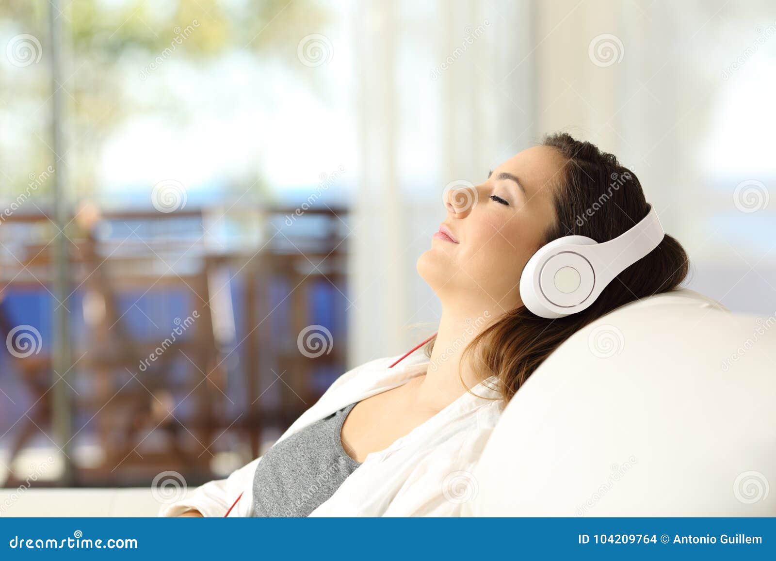 woman relaxing listening to music on a couch