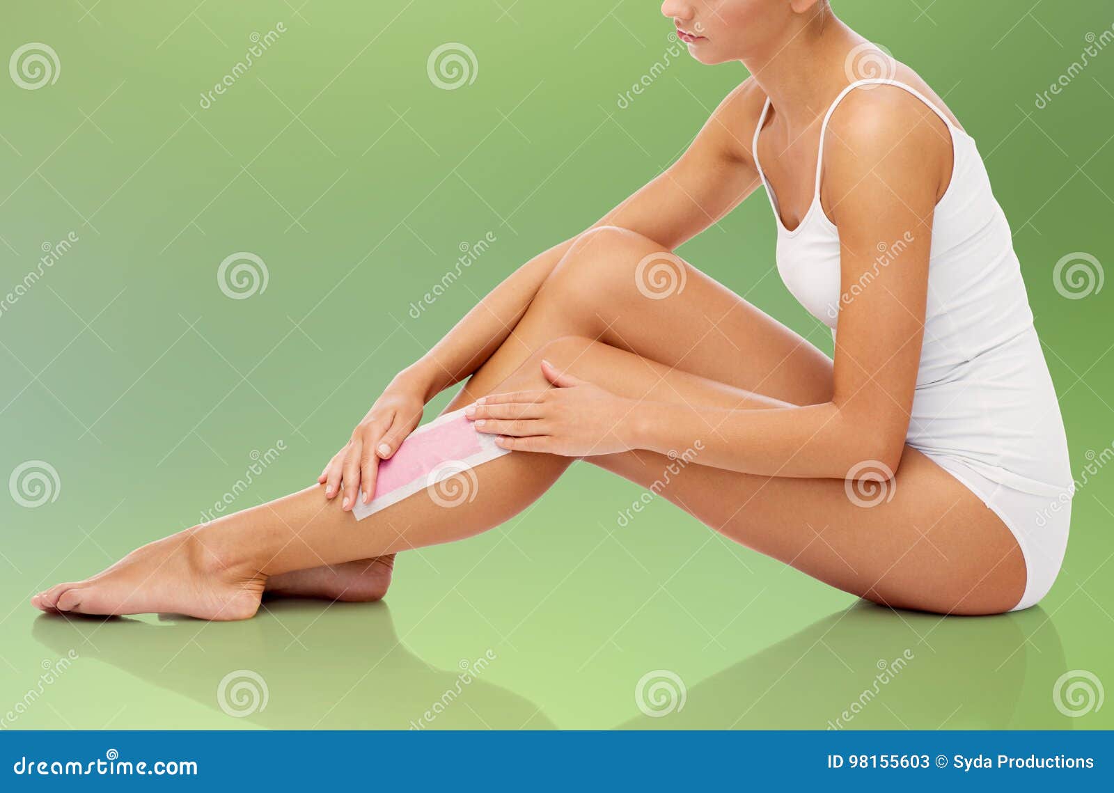 woman removing leg hair with depilatory wax strip