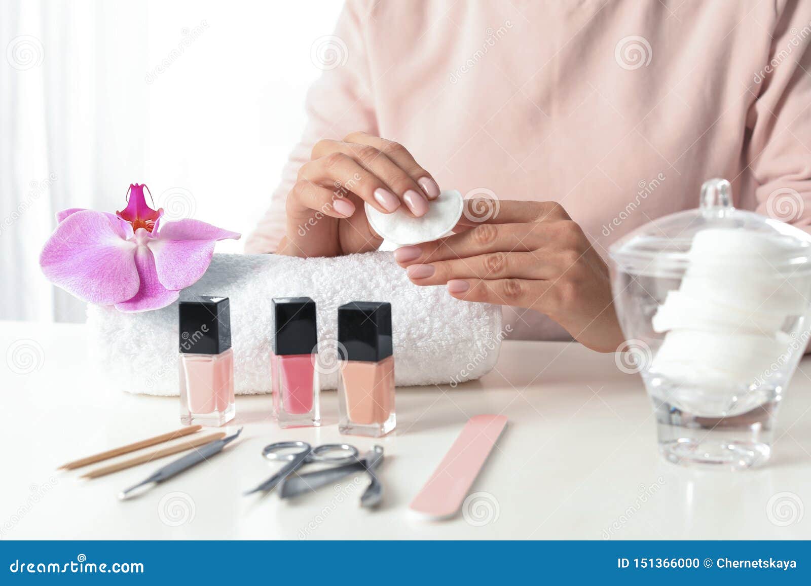 Woman Removing Polish from Nails with Cotton Pad at Table Stock Photo ...