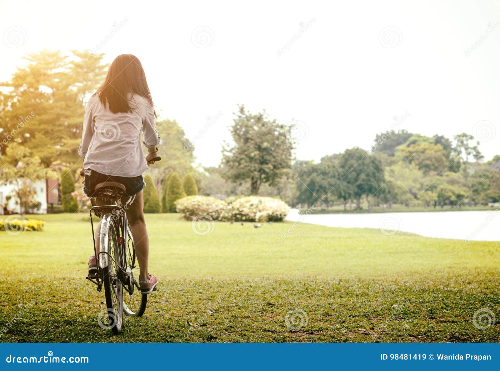 woman riding a bicycle in a park outdoor at summer day. active people. lifestyle concept.