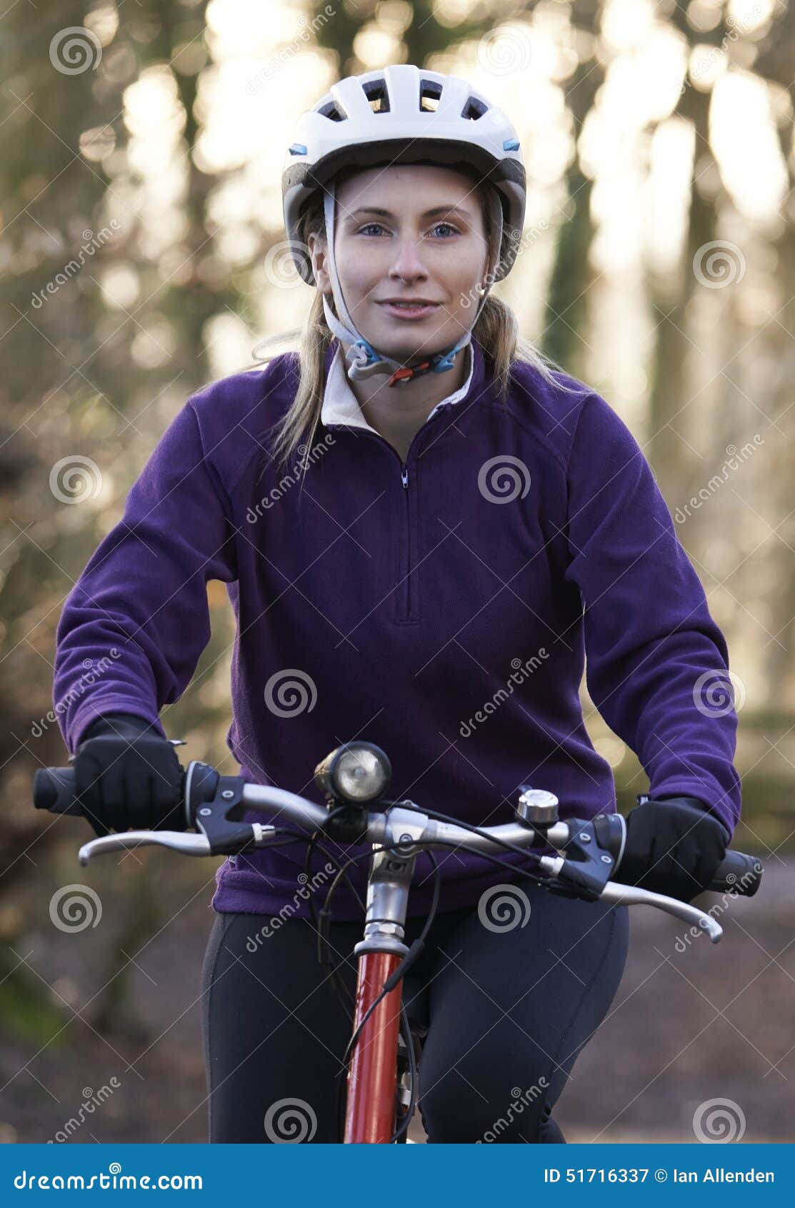 woman riding mountain bike through woodlands