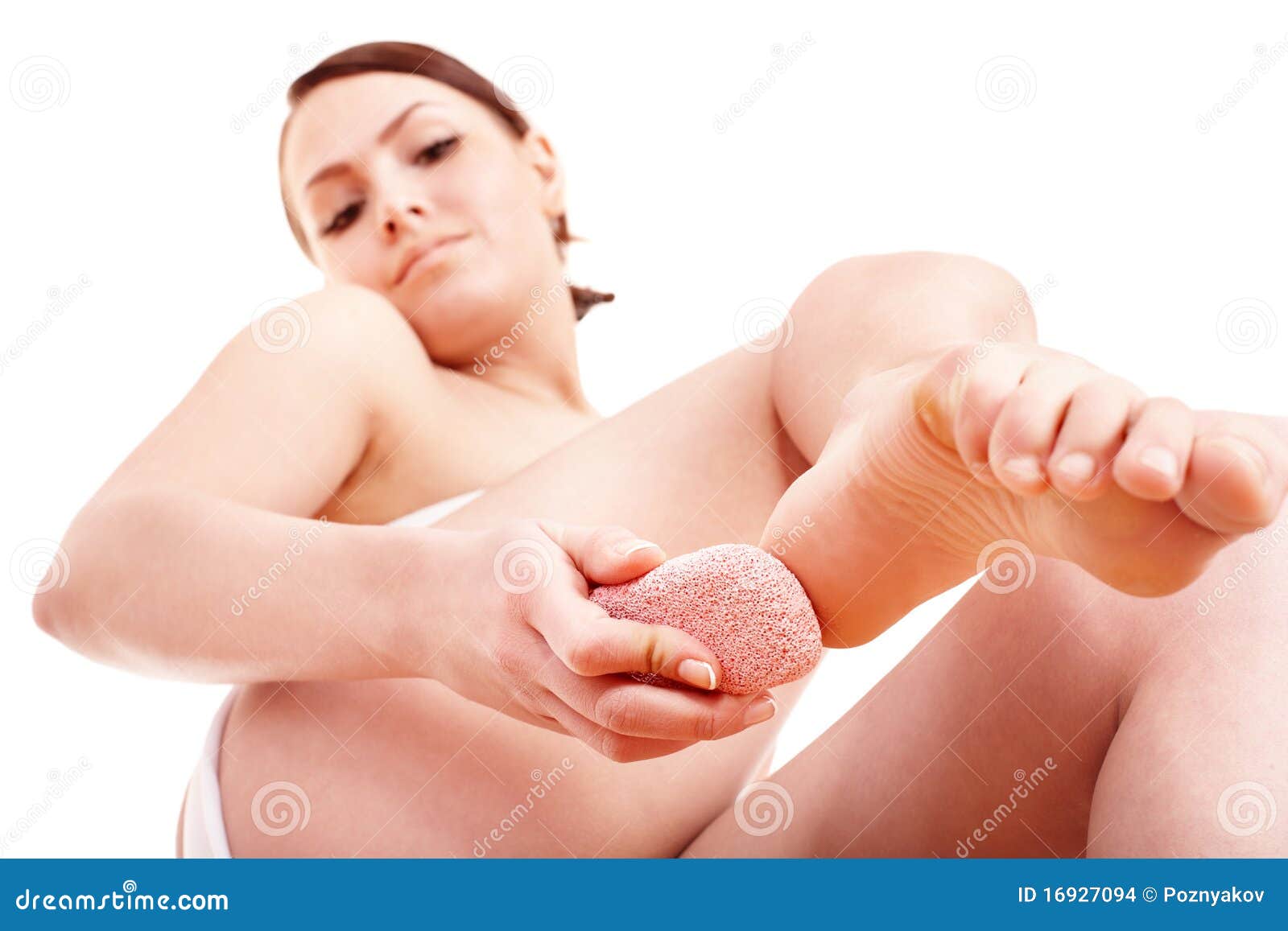 woman rubbing heel of foot with pumice stone.