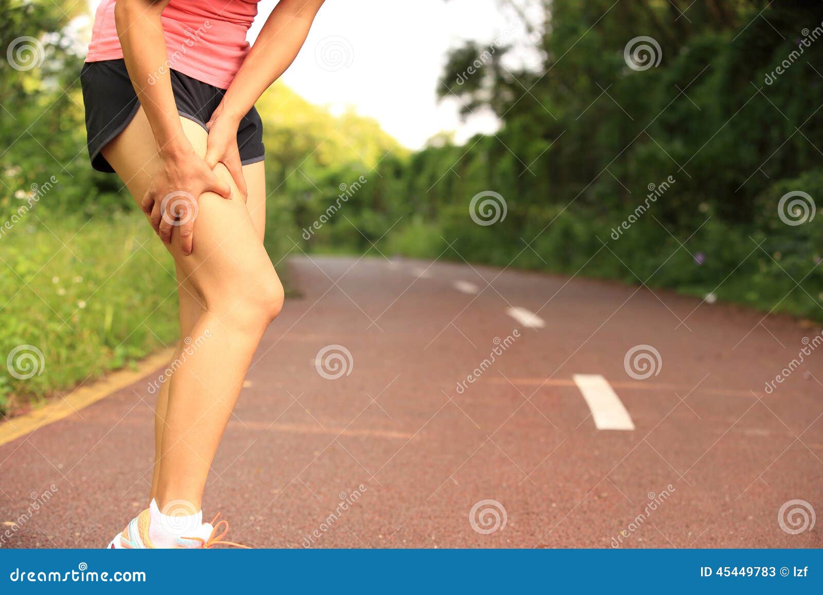 woman runner holder her sports injured legs