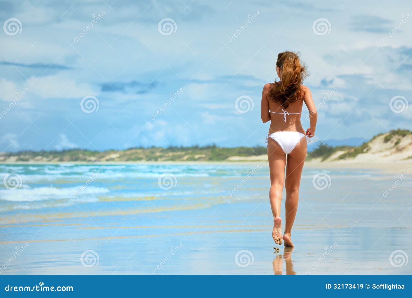 A Woman Running Along The Beach In A White Bikini Royalty Free Stock
