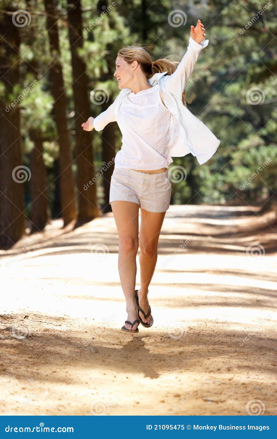 woman running freely along country path