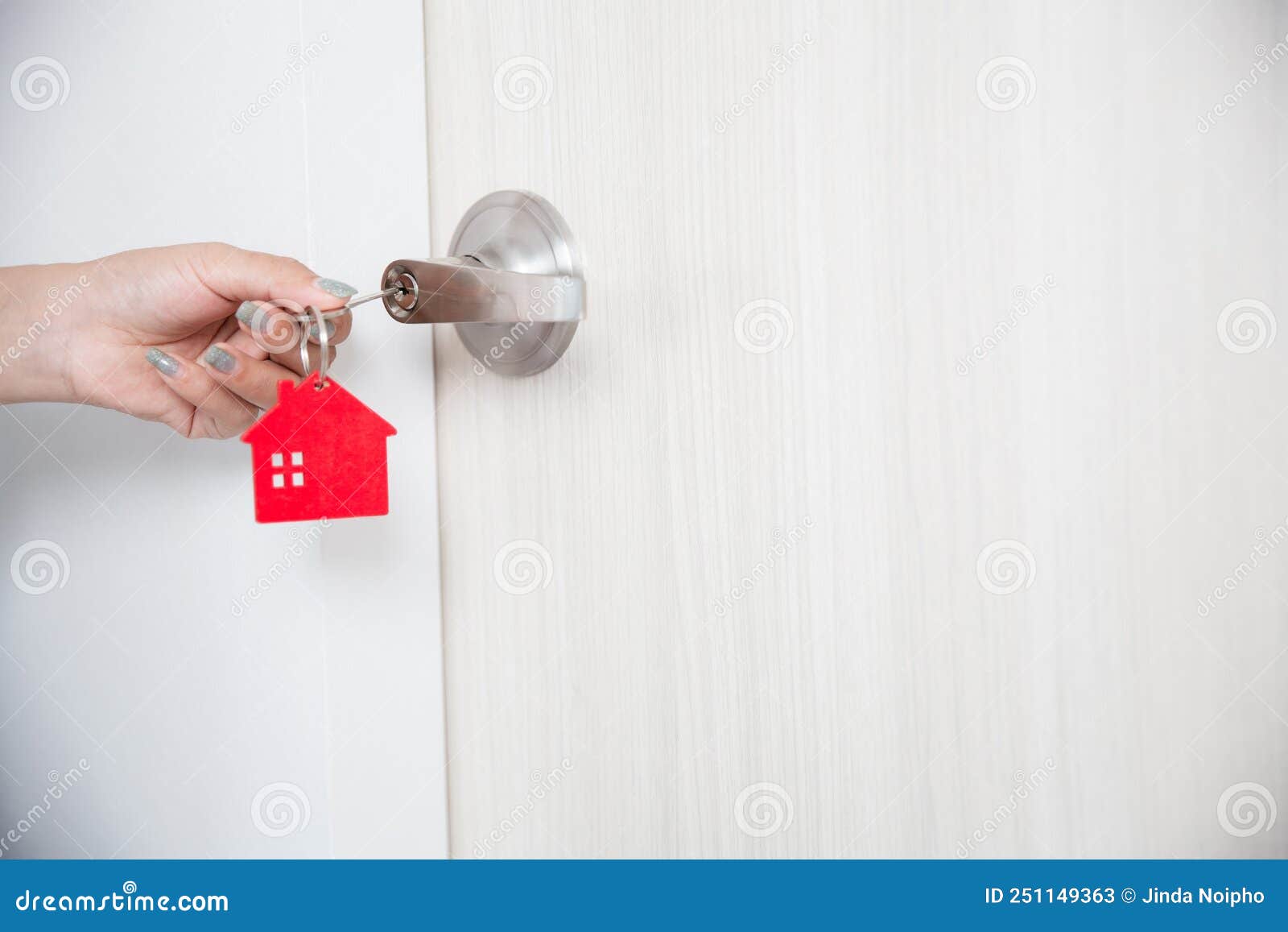 a woman`s hand opens the door with a key
