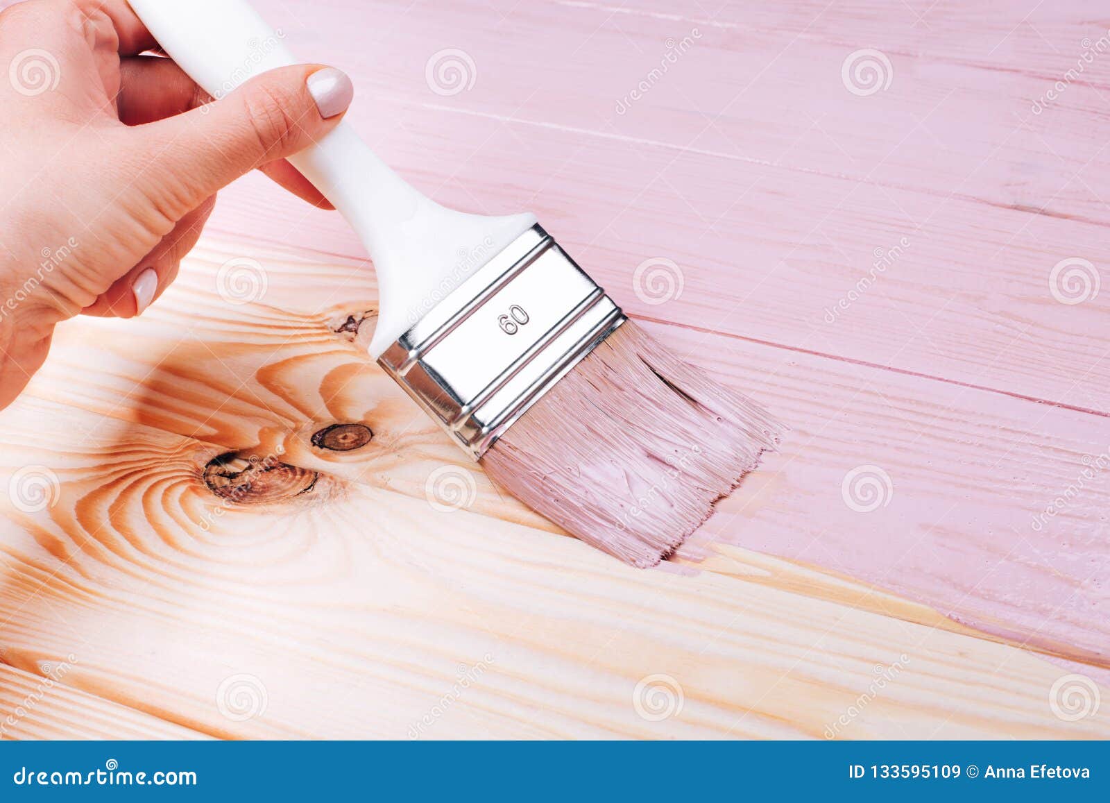 Woman S Hand With White Brush Applying Pink Paint On Wooden