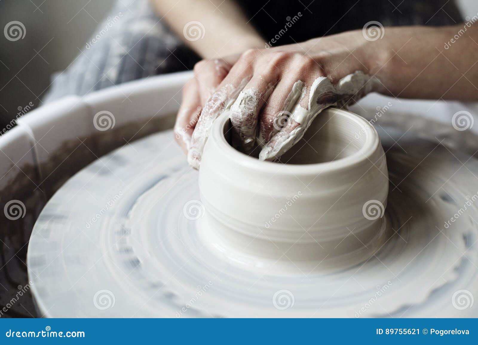 the woman`s hands close up, the masterful studio of ceramics works with clay on a potter`s wheel.