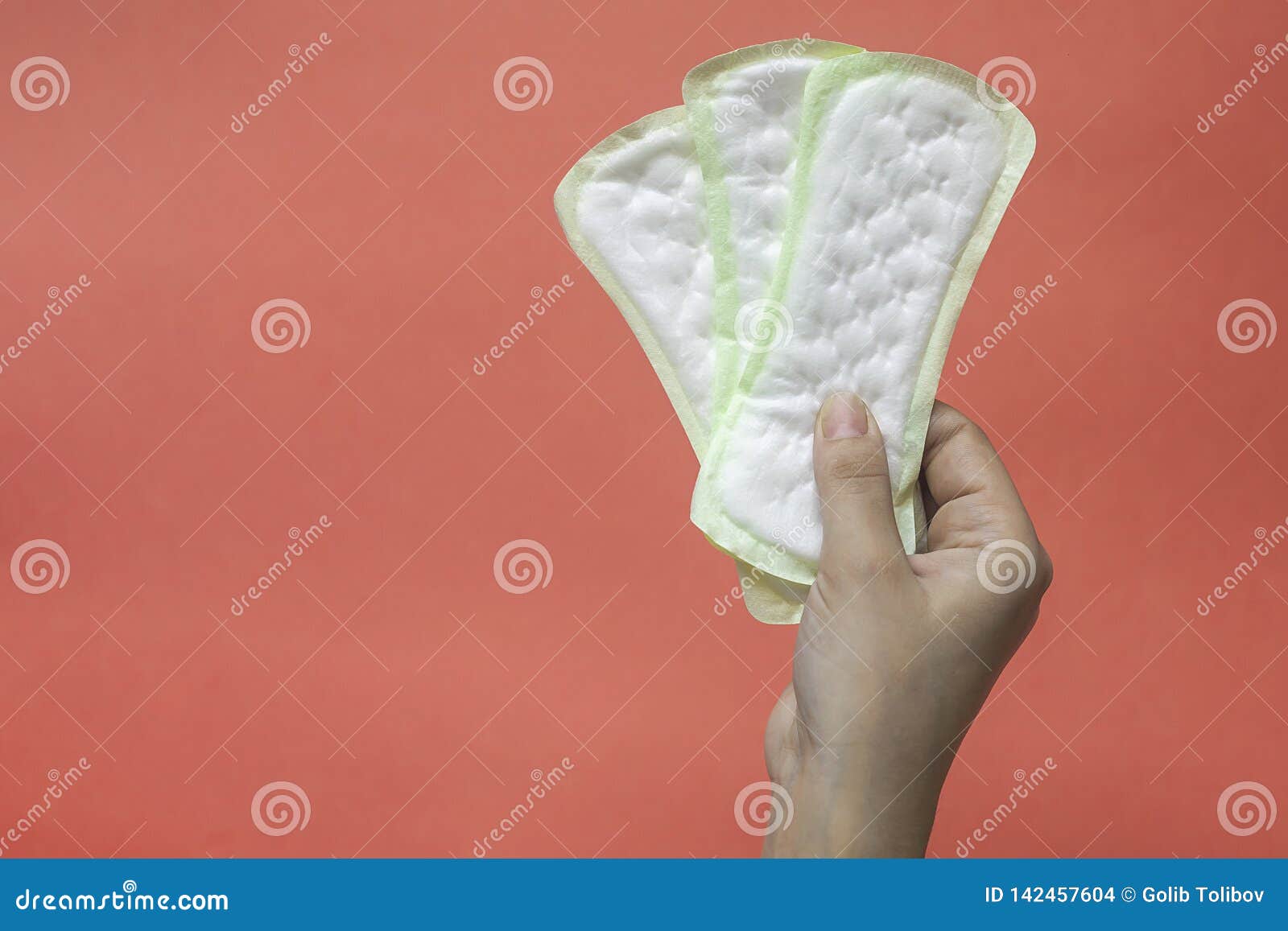 woman`s hands holding feminine hygiene pads. hands of female hold menstrual pads or sanitary napkins for women