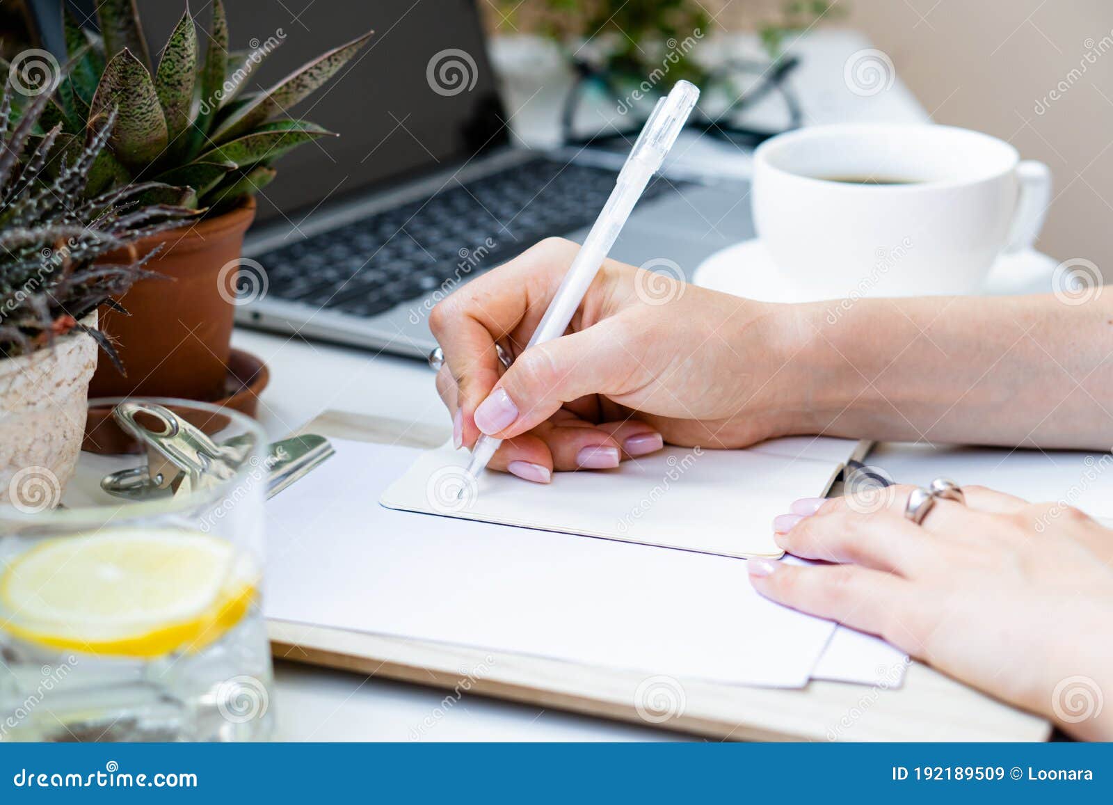 Woman`s Hands Making Notes in Notepad in Cozy Summer Office with Laptop ...