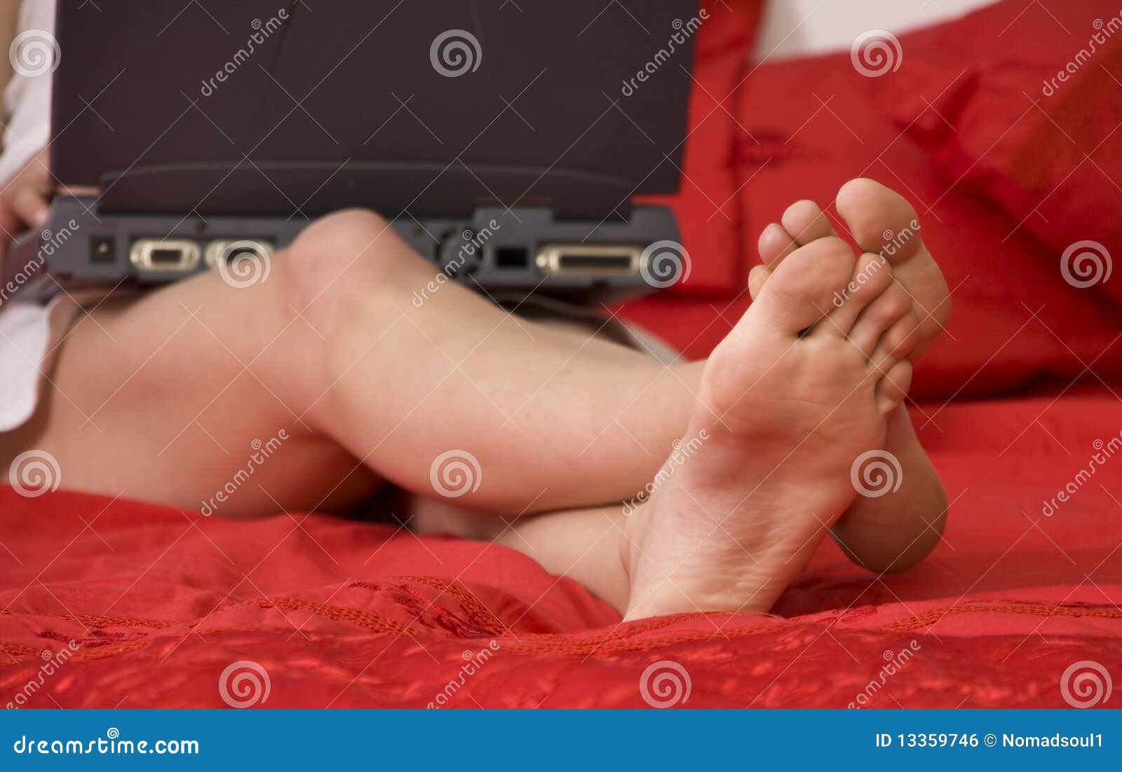 Woman s legs in bed stock photo. Image of person, notebook 13359746