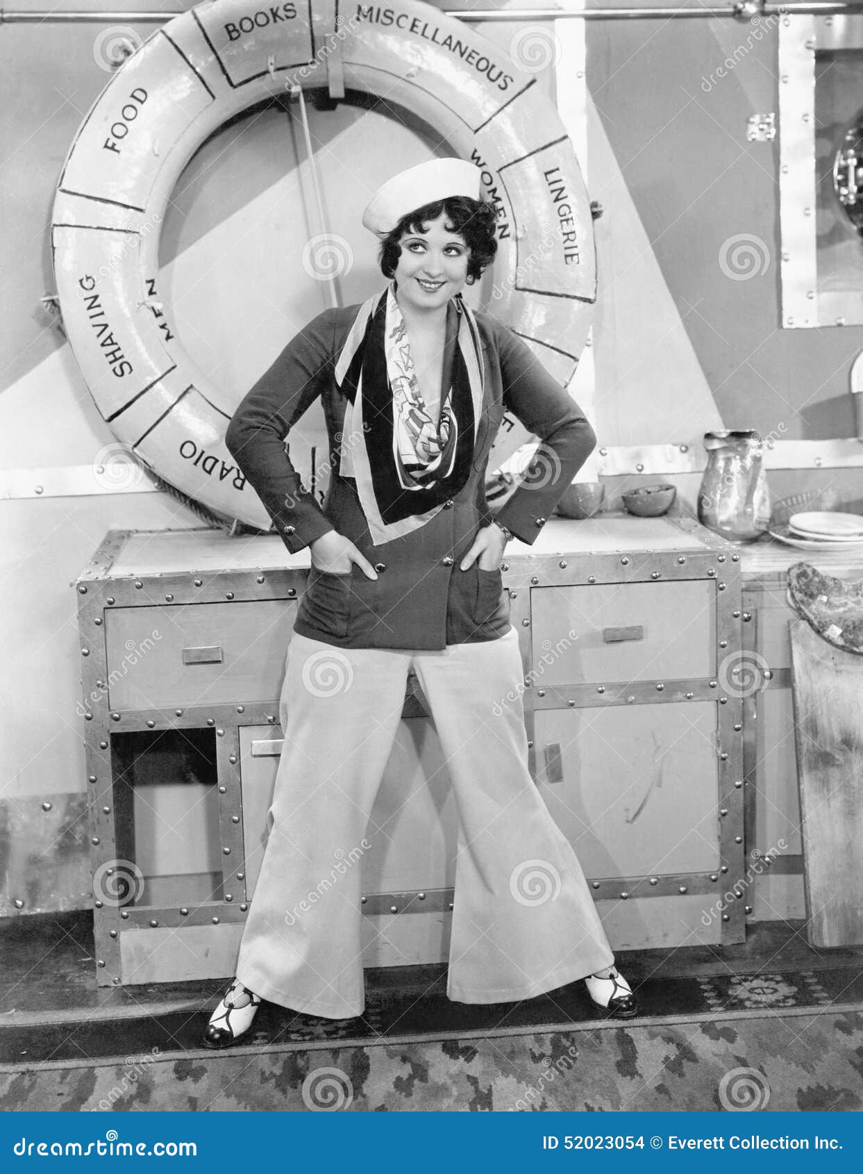 woman in a sailors outfit in front of a life preserver