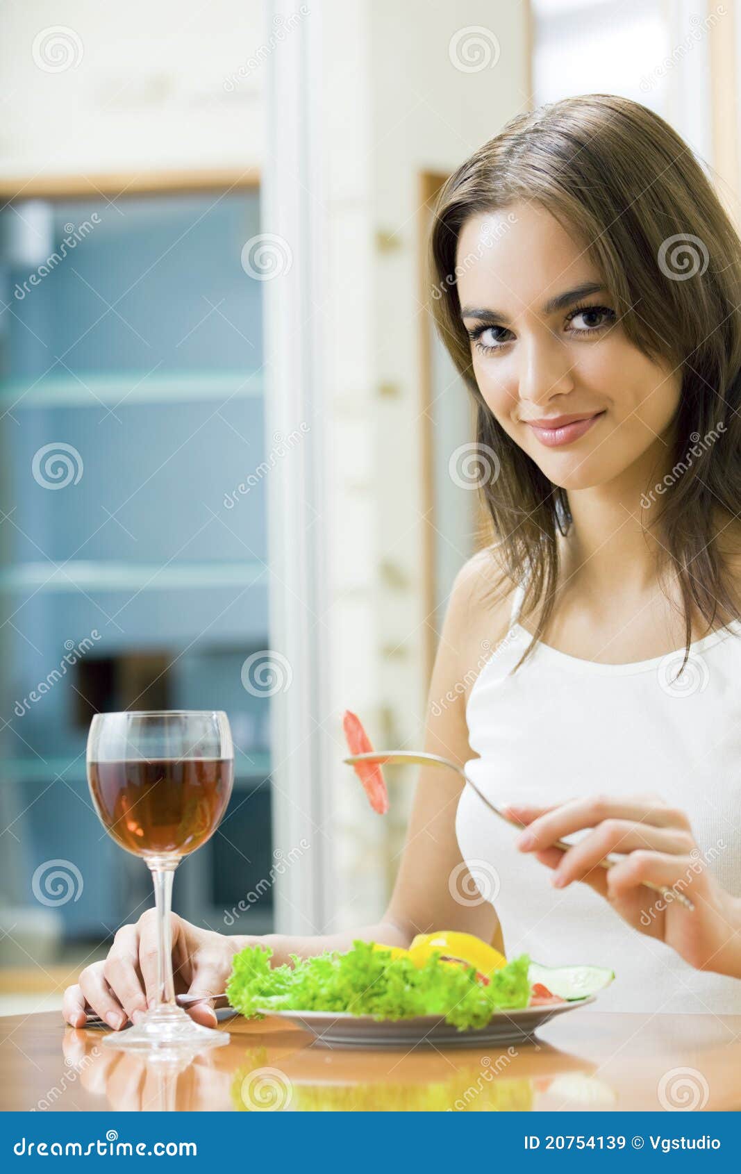 Woman with salad and redwine at home