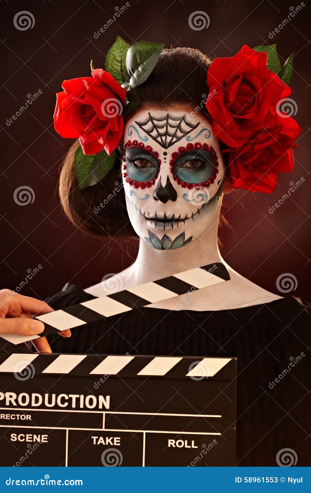 woman in santa muerte mask behind clapboard