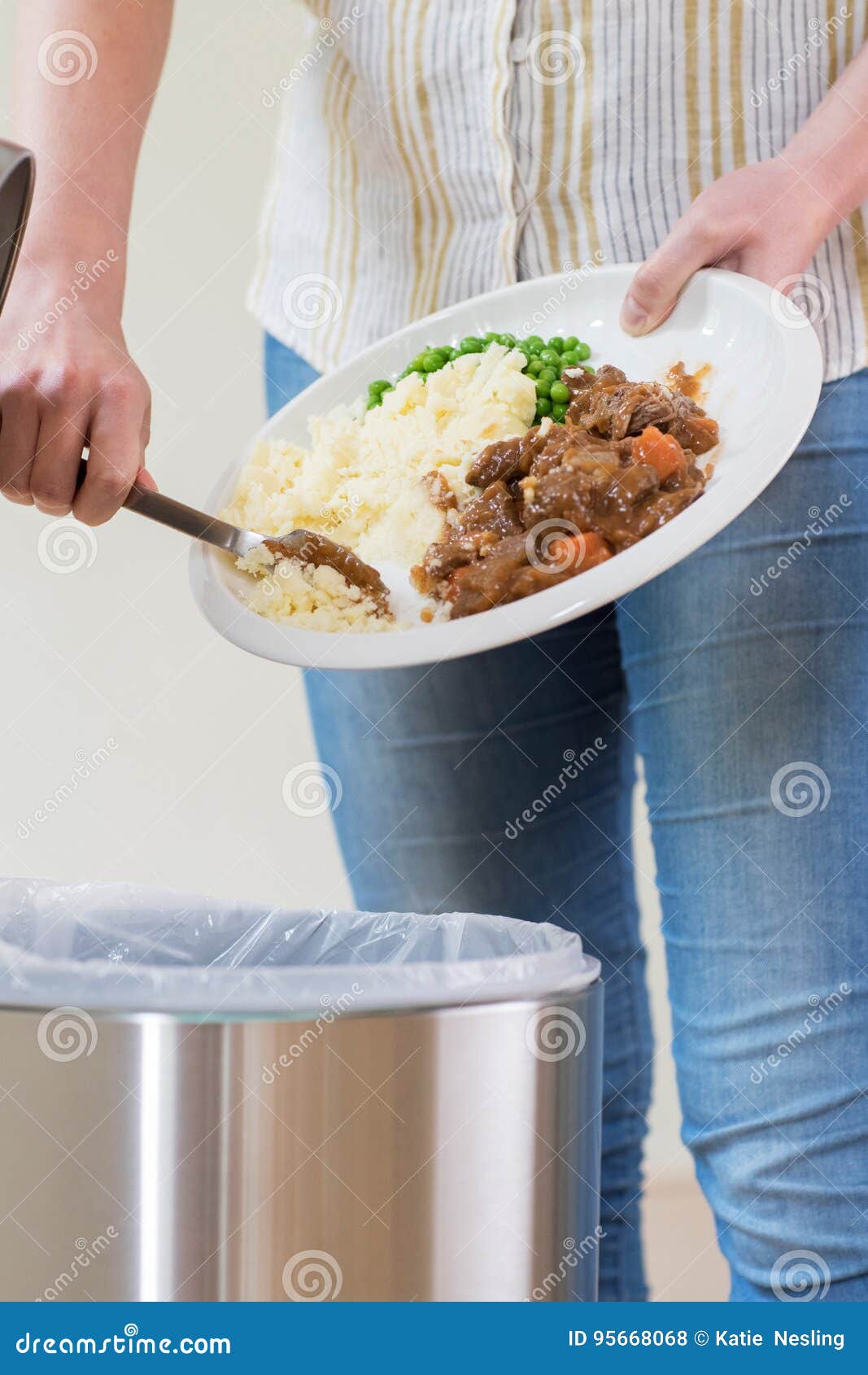 woman scraping food leftovers into garbage bin