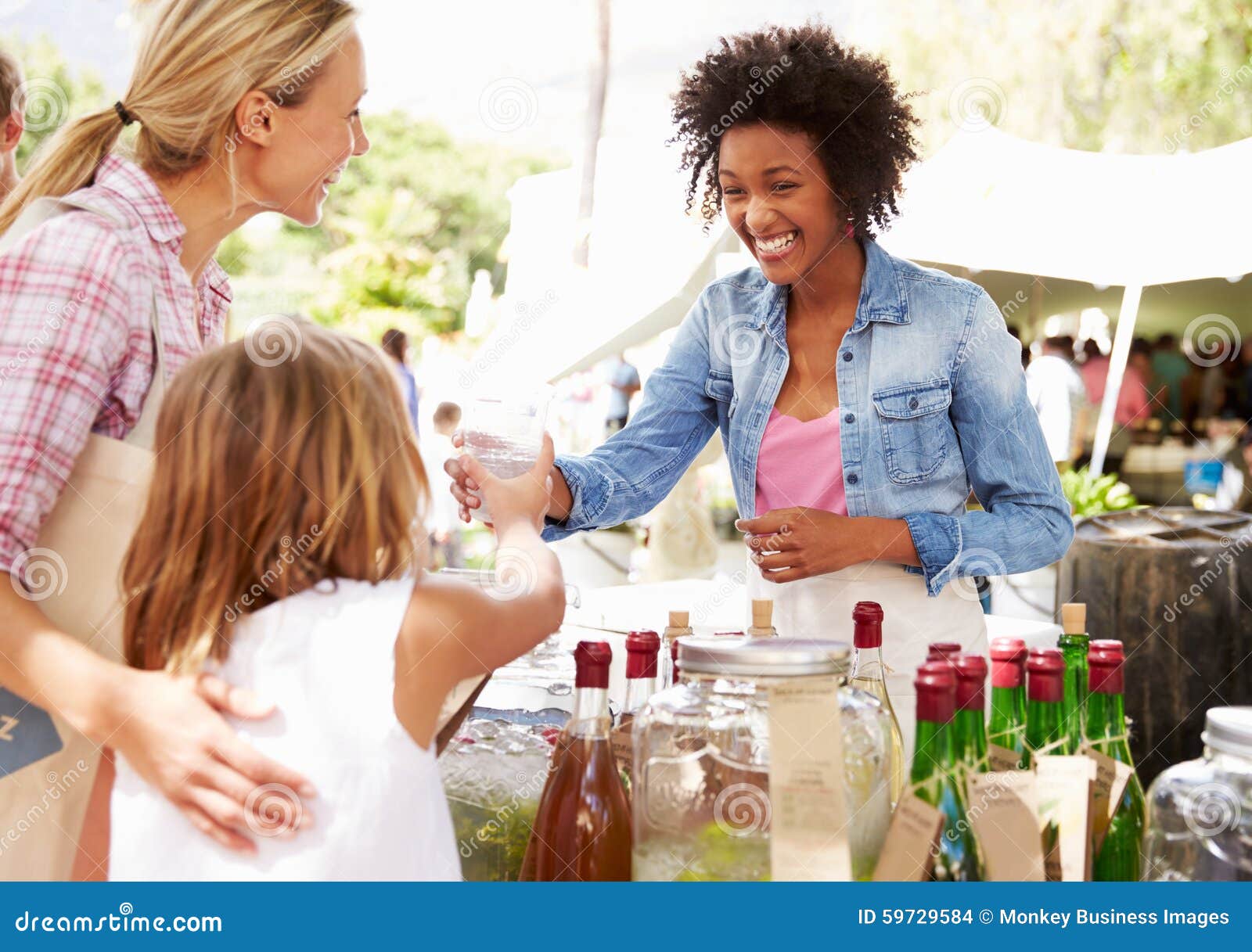 woman selling soft drinks at farmers market stall