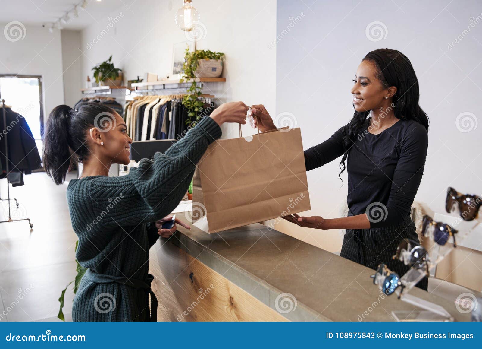 woman serving customer at the counter in a clothing store