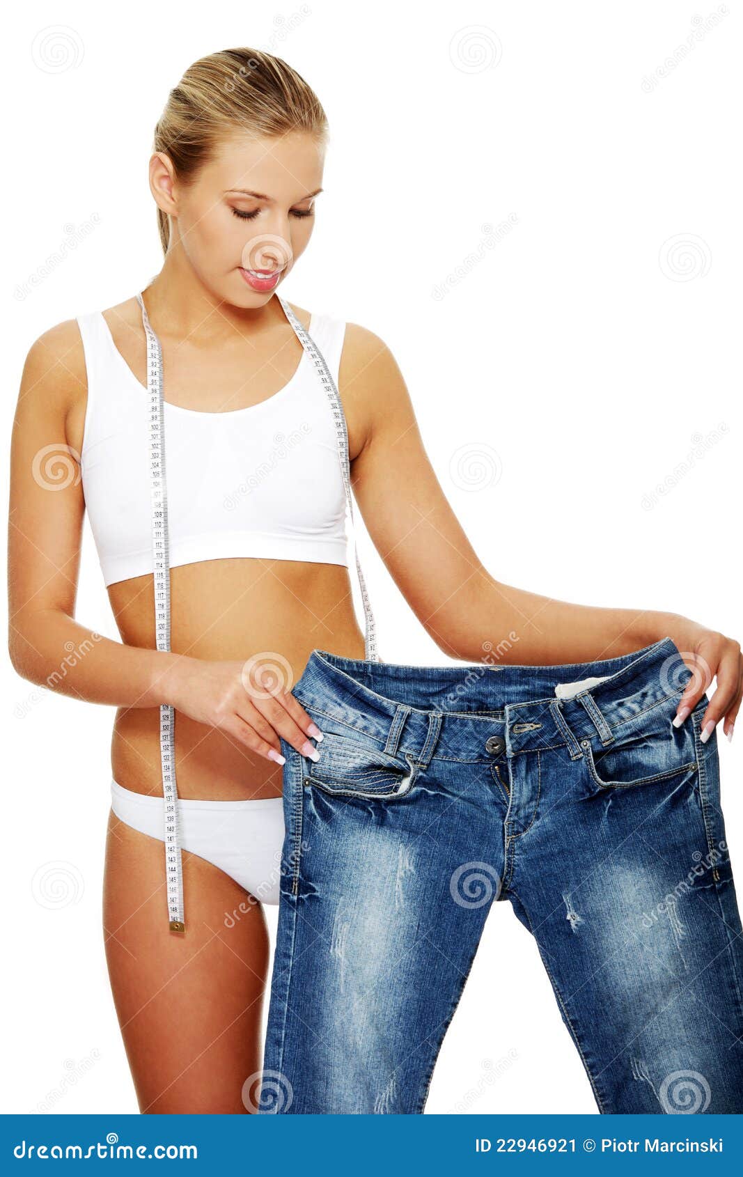 Young Slim Woman Showing How Much Weight She Lost. Stock Photo, Royalty-Free