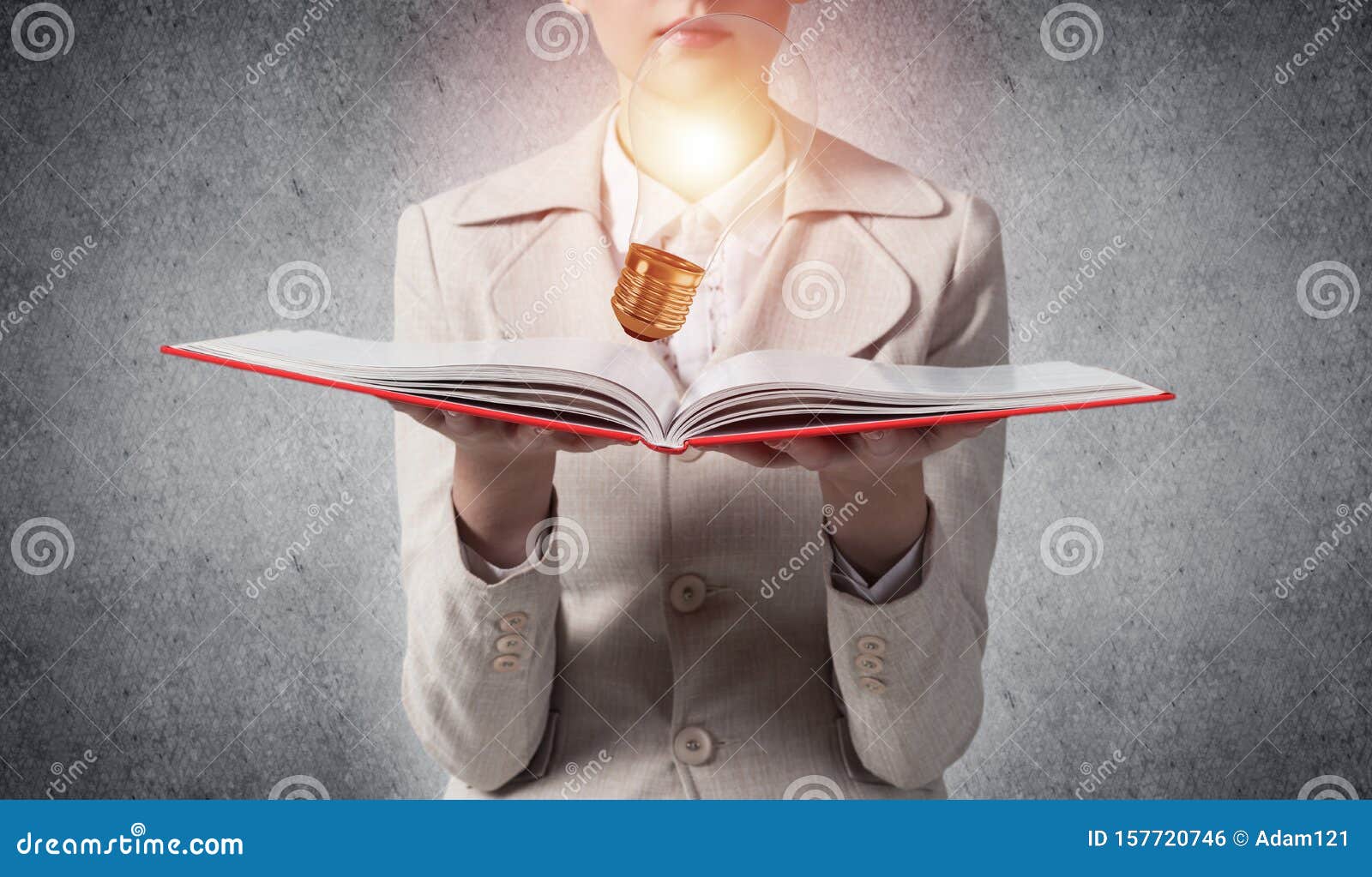 woman showing shining light bulb on open book