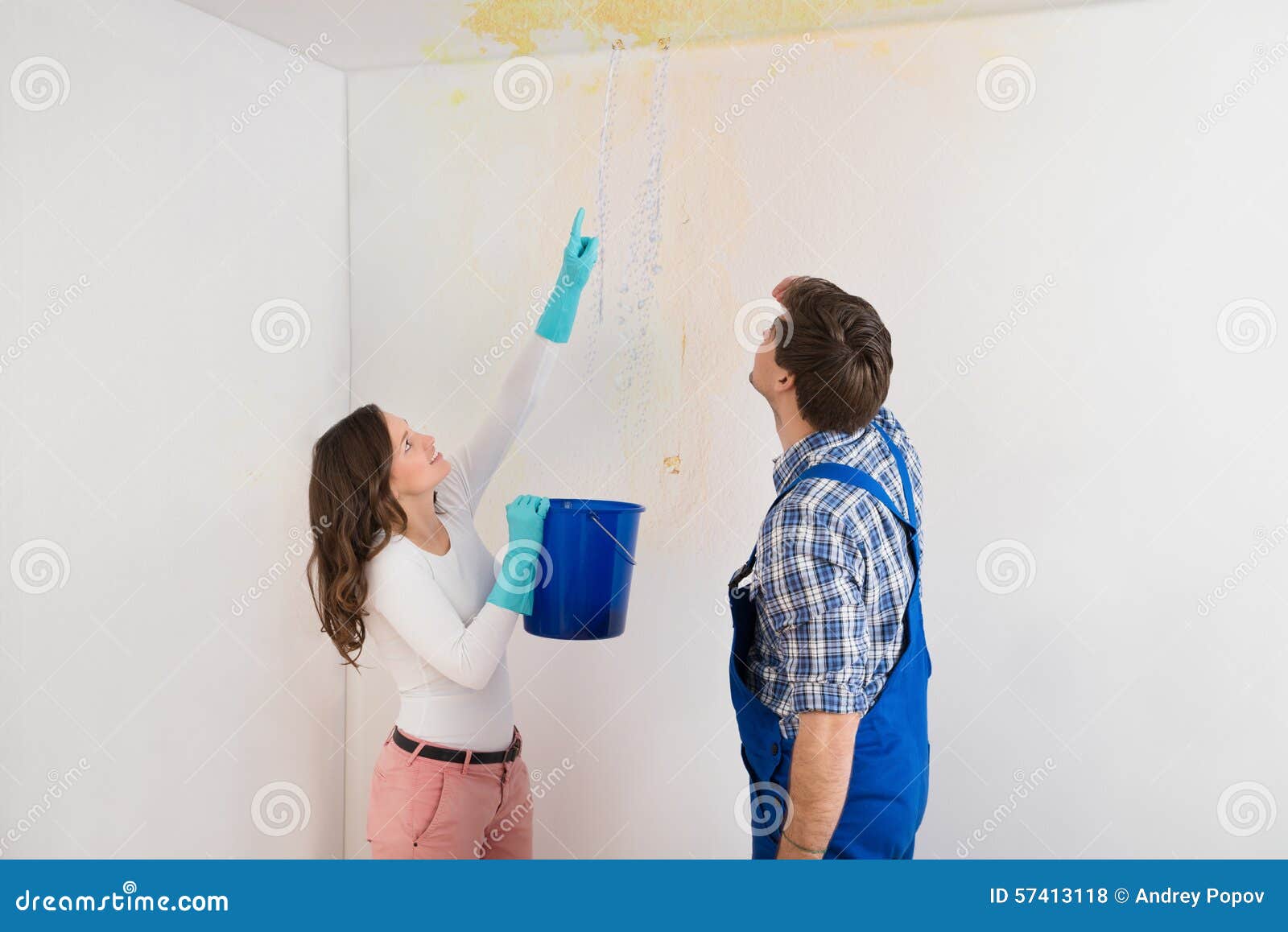 Woman Showing Water Leaking From Ceiling To Maintenance Guy Stock