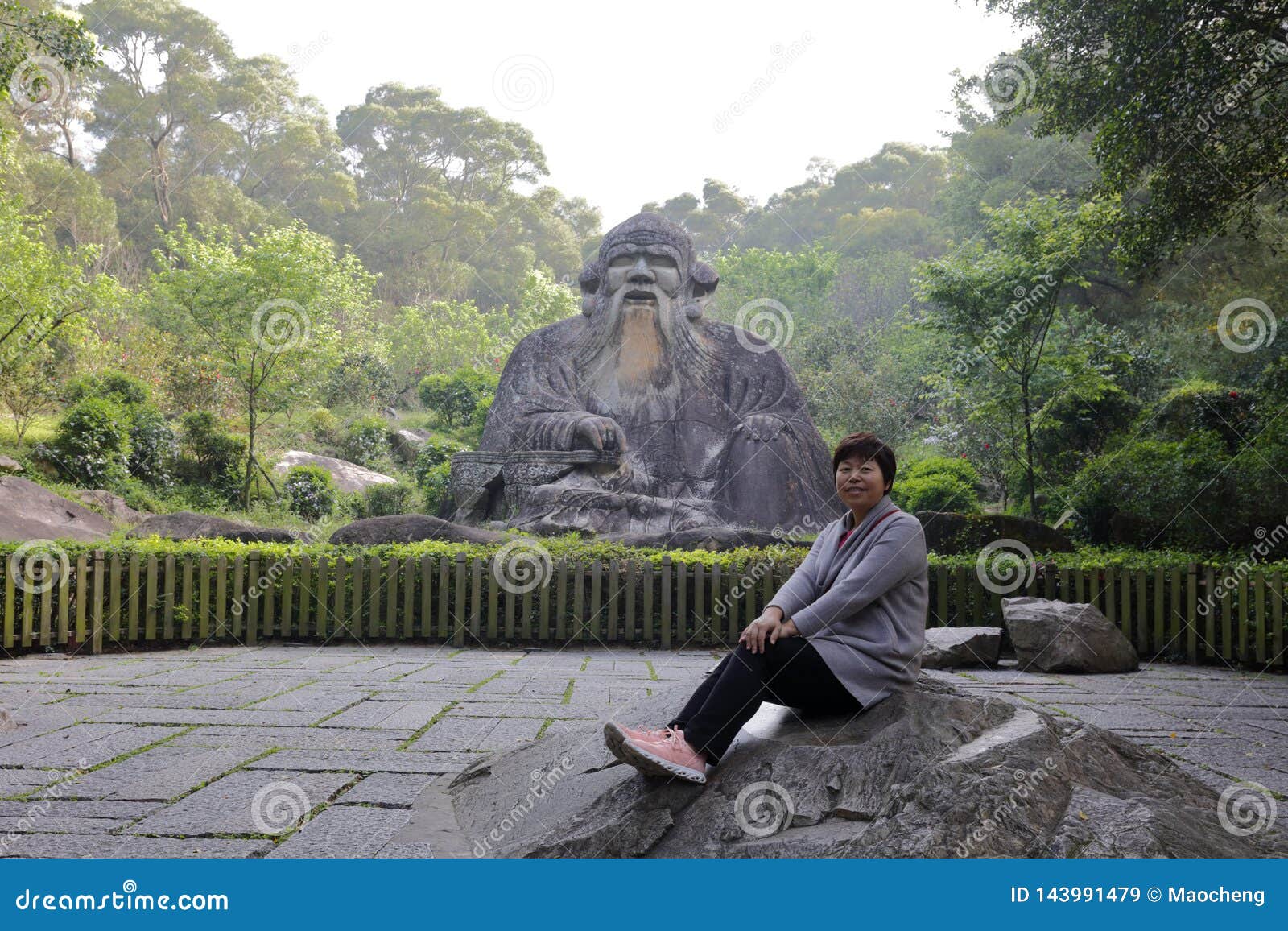 woman sit before laozi statue of qingyuanshan mountain, adobe rgb
