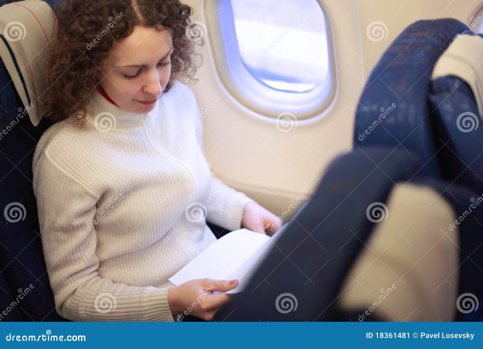 woman sits in chair near illuminator of airplane