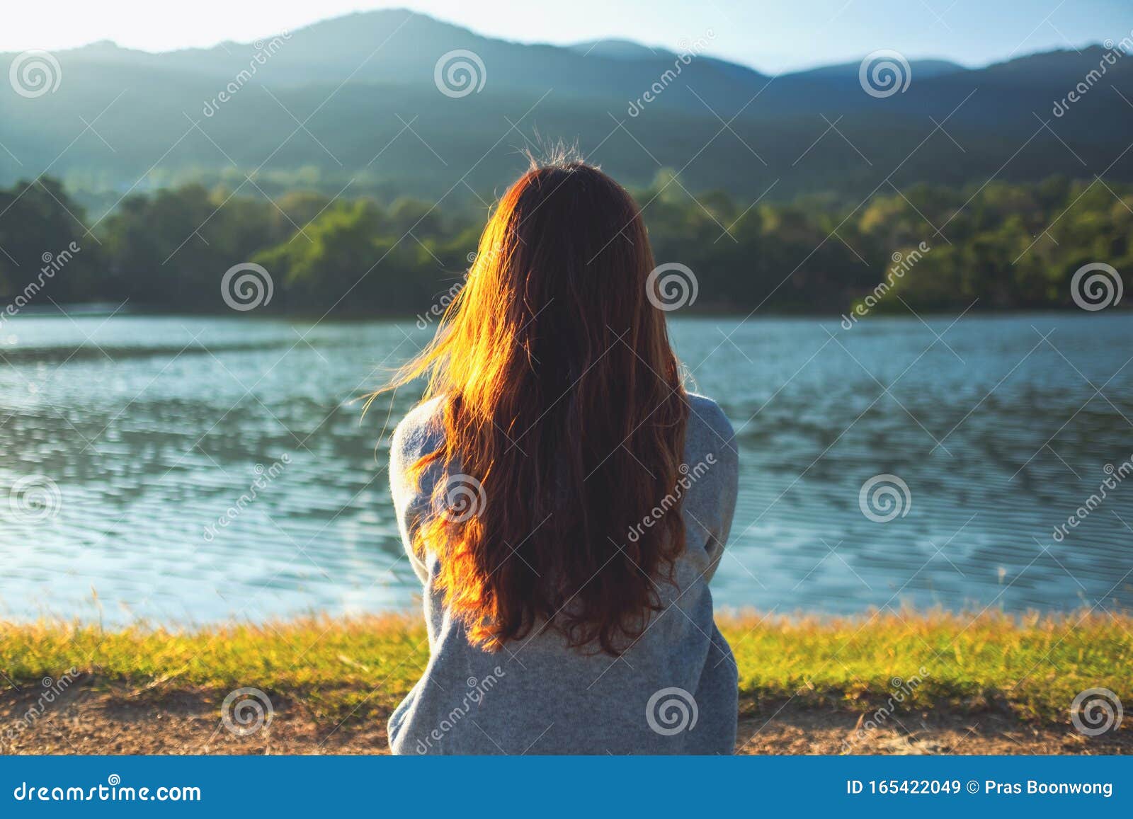 Trickle krone grundigt A Woman Sitting Alone by the Lake Looking at the Mountains with Green Nature  Stock Image - Image of adult, clouds: 165422049