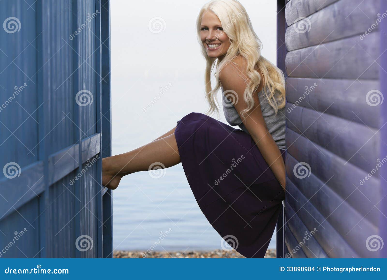 Woman Sitting On Balustrade Of Beach Cabin Stoc picture pic