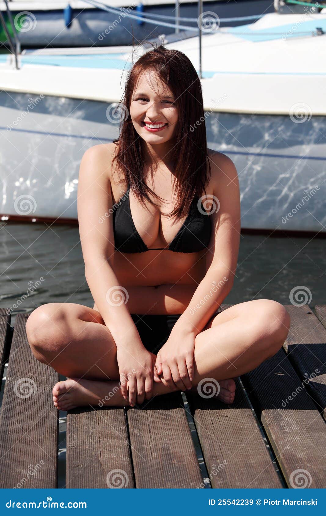 woman sitting in black bikini in yacht harbor. stock image