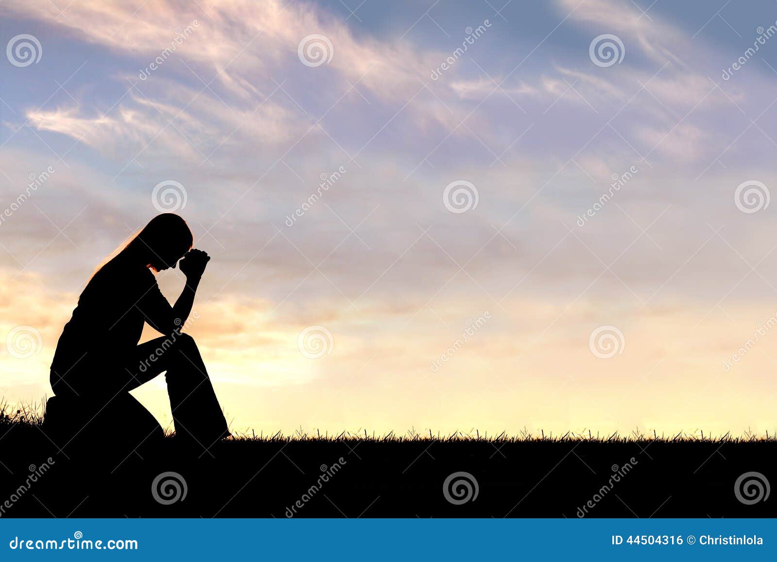woman sitting down in prayer silhouette