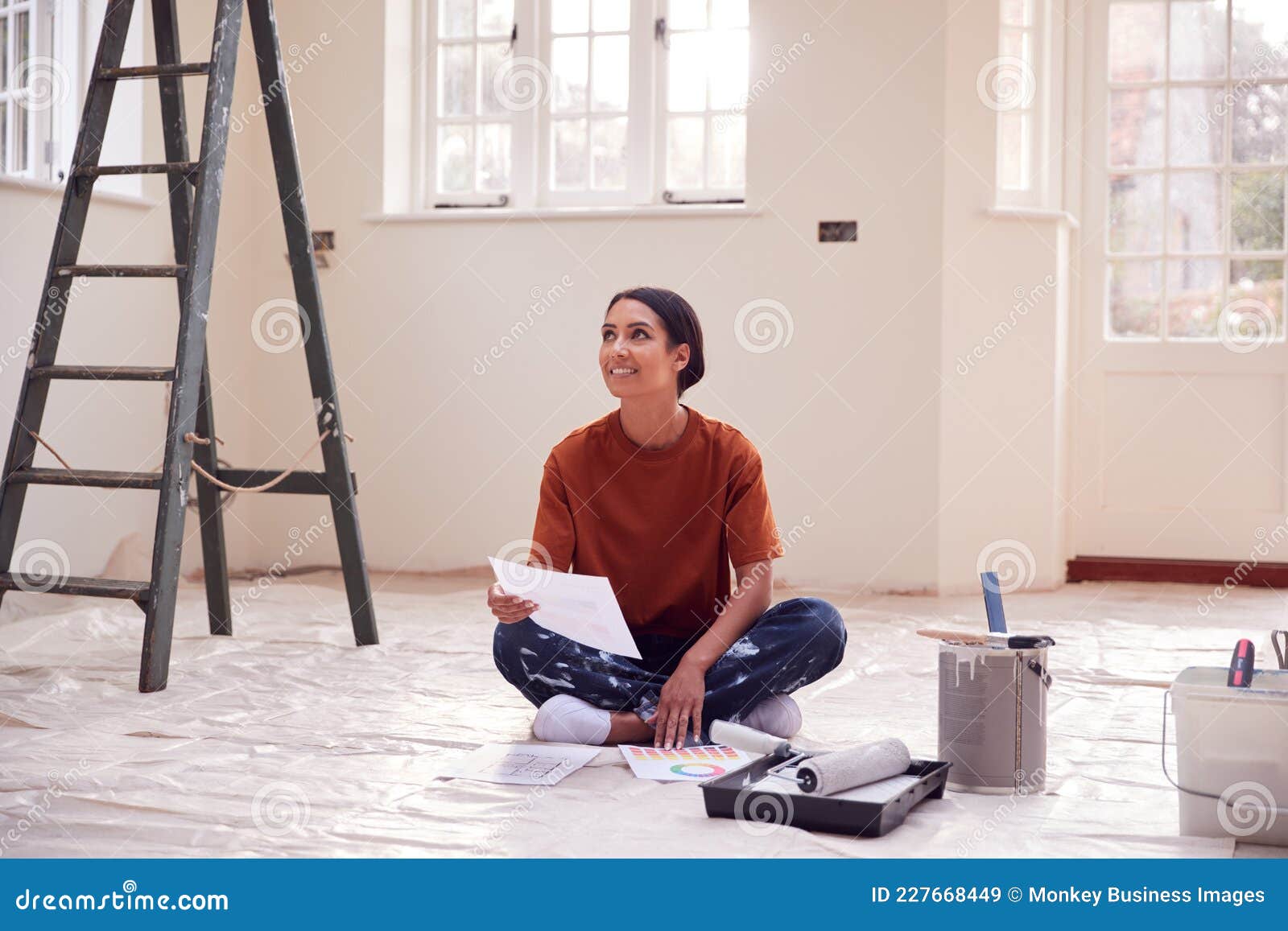 Woman Sitting on Floor with Paint Chart Ready To Decorate New Home ...
