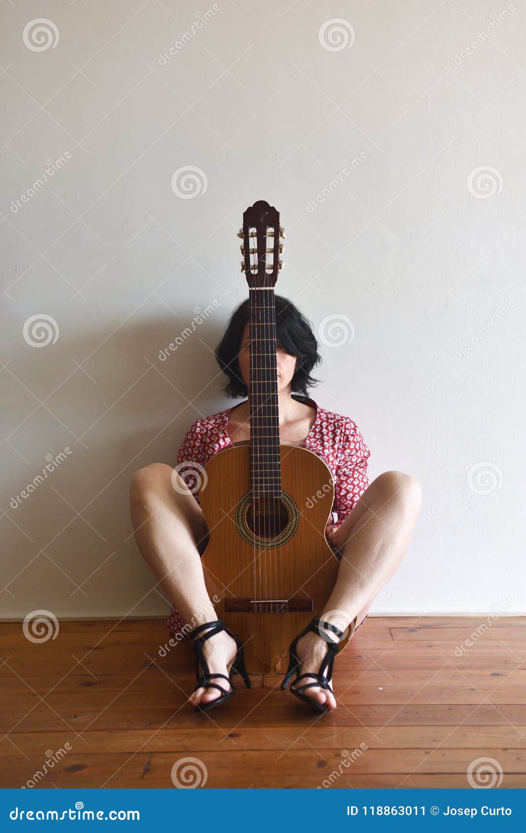 a woman sitting with a guitar