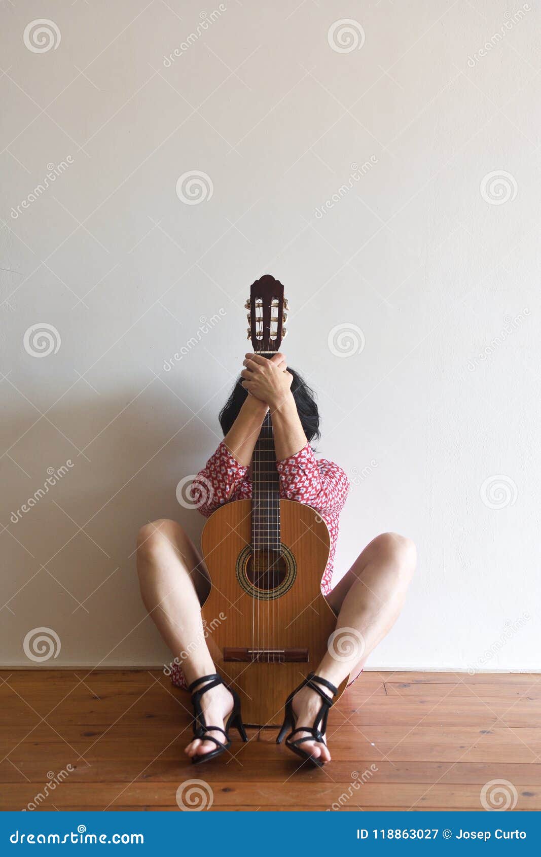 a woman sitting with a guitar