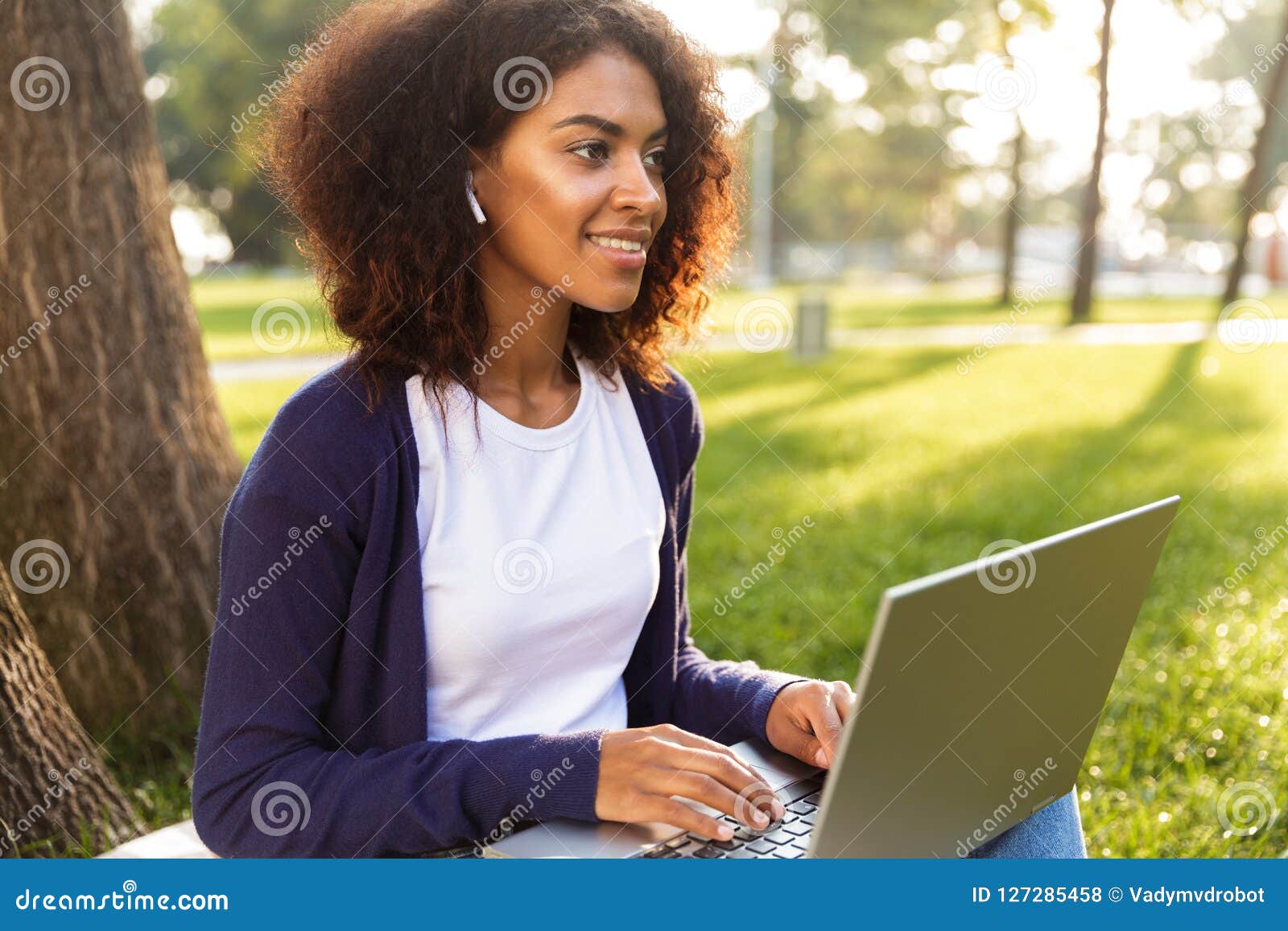 Woman sitting on a toilet using laptop computer Stock 