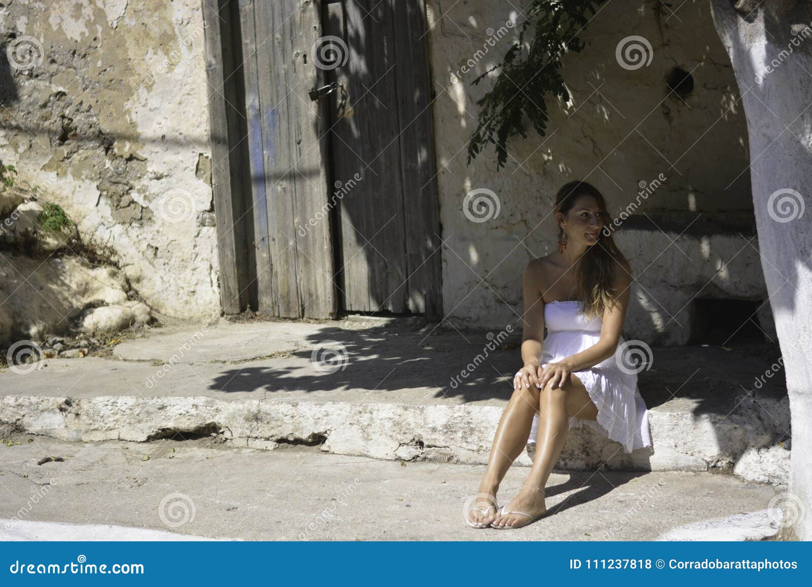 the woman sitting in the shade of a tree