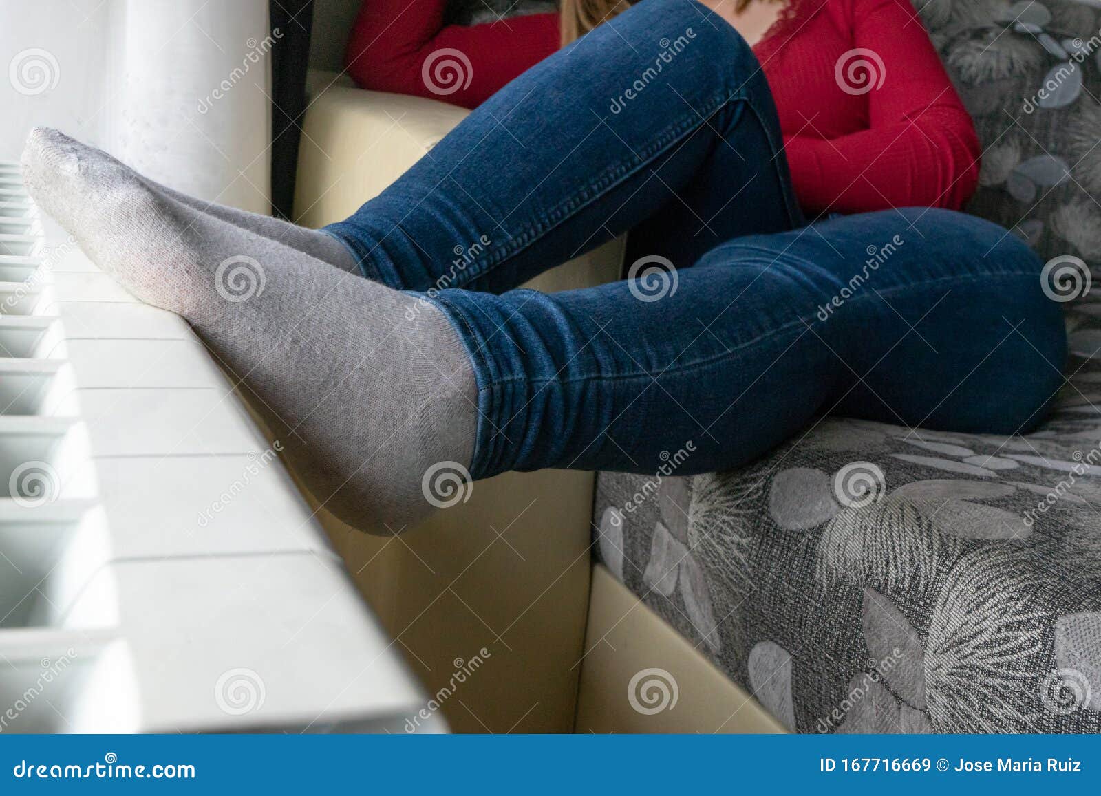 Woman Sitting In The Sofa With The Feet Warming In The Central Heater