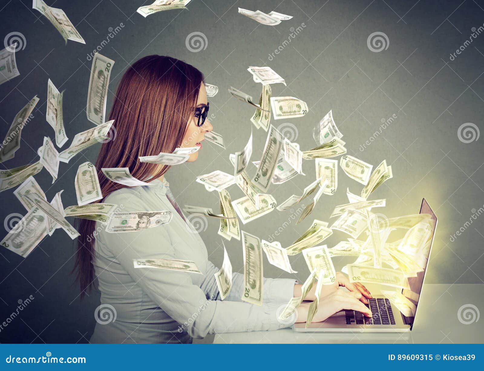 woman sitting at table using working on a laptop computer making money