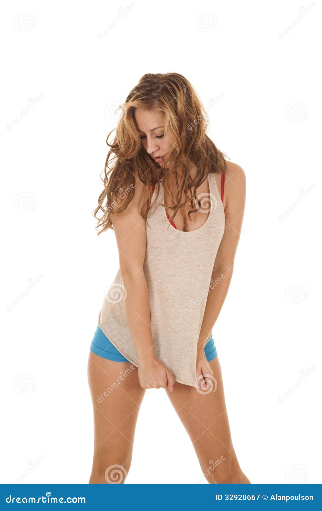 A woman in her underwear pulling down on her shirt. 