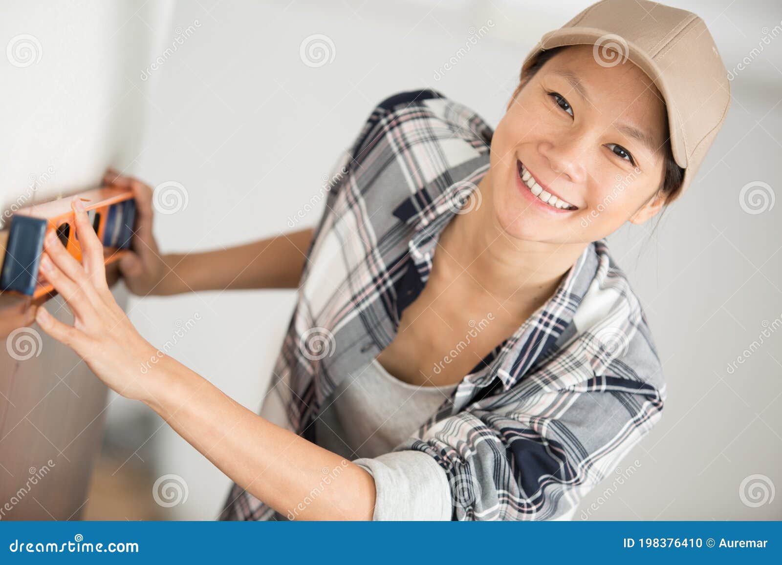 woman smiling at camera while holding sprit level
