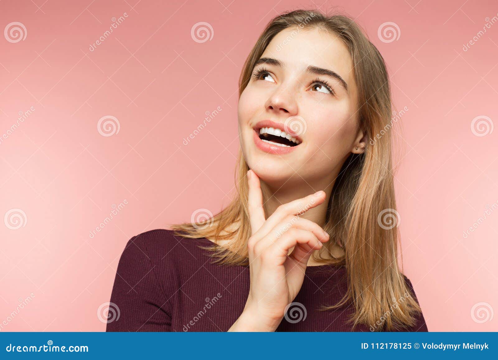 woman smiling with perfect smile and white teeth on the pink studio background