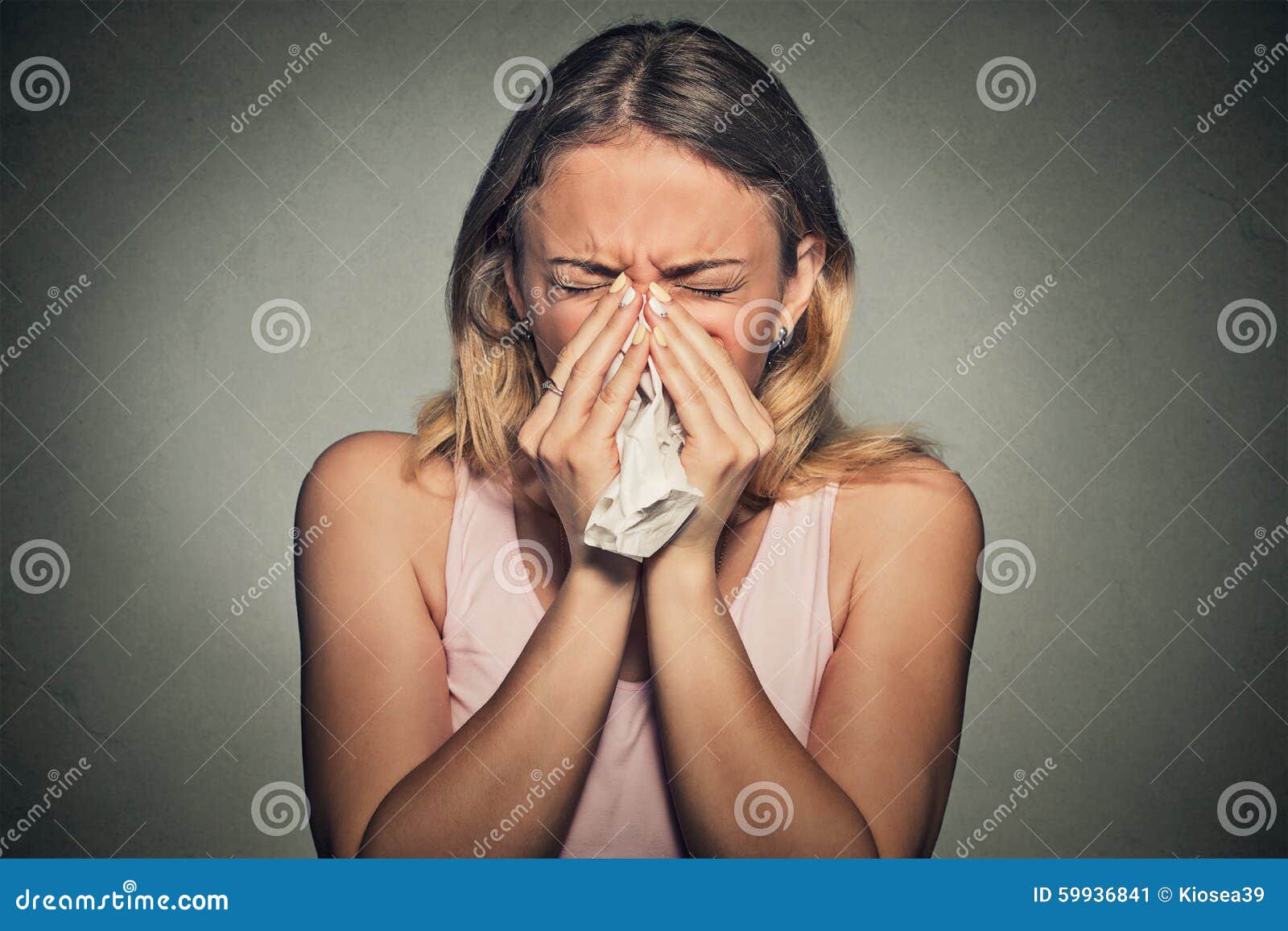 woman sneezing blowing her runny nose