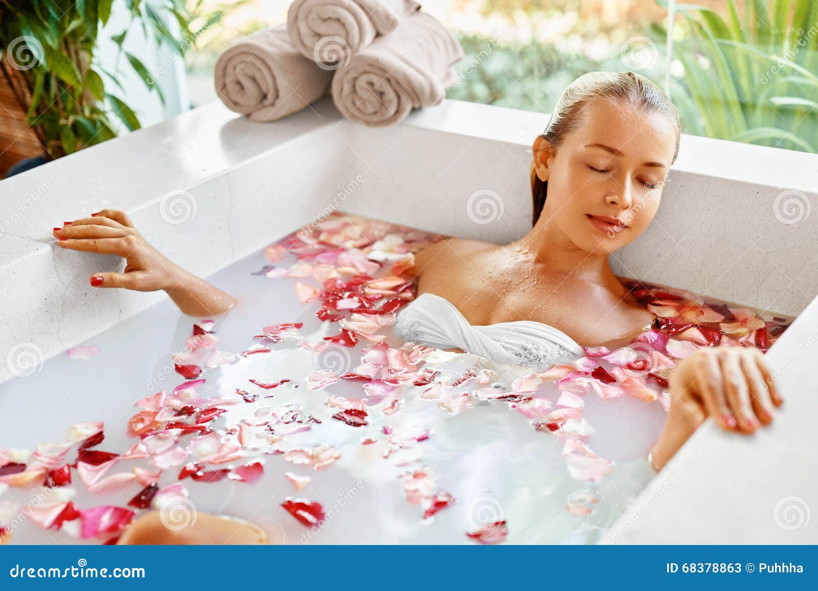 woman spa flower bath. aromatherapy. relaxing rose bathtub. beauty