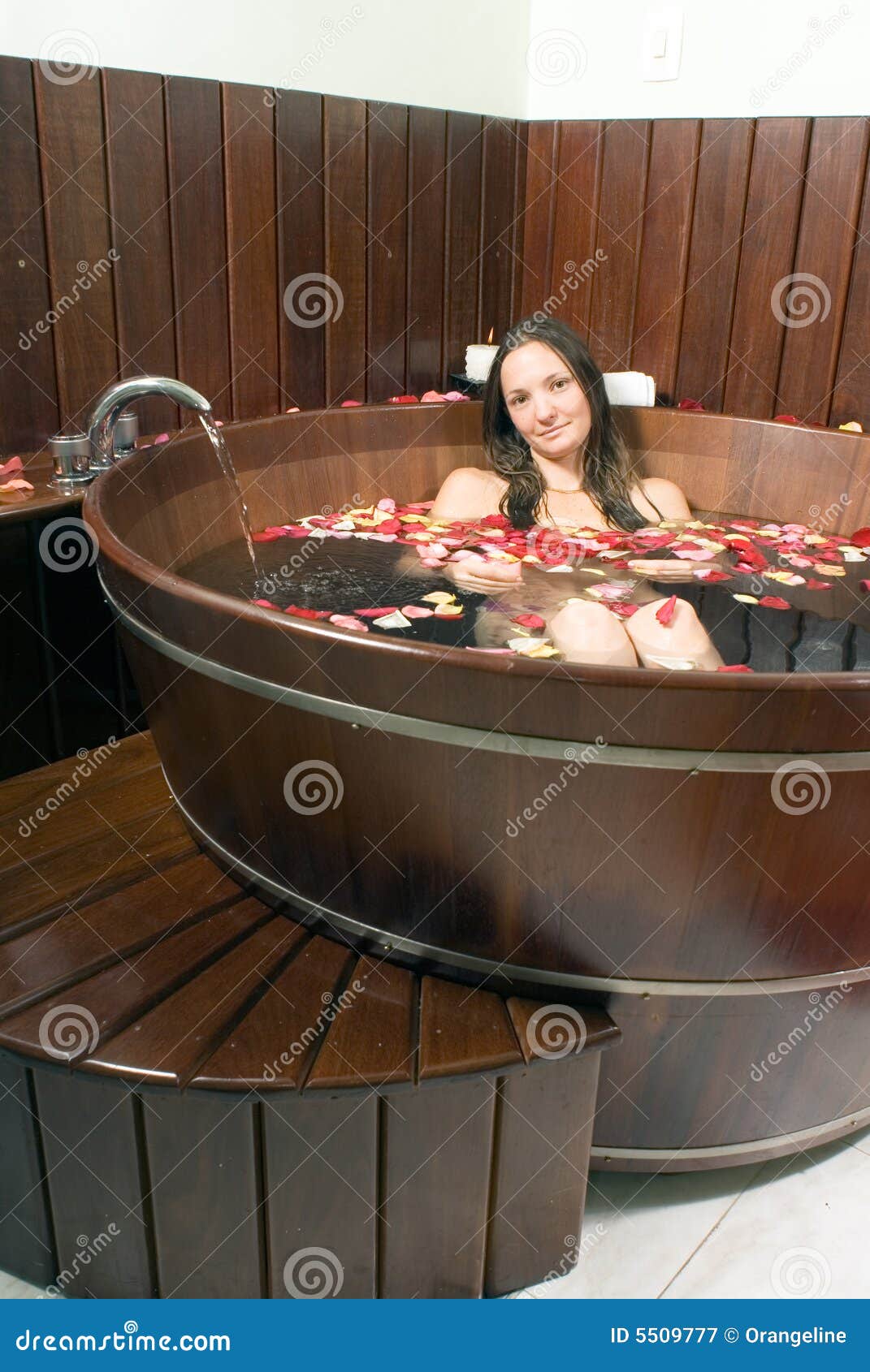 woman at a spa soaking in a large wooden bathtub stock