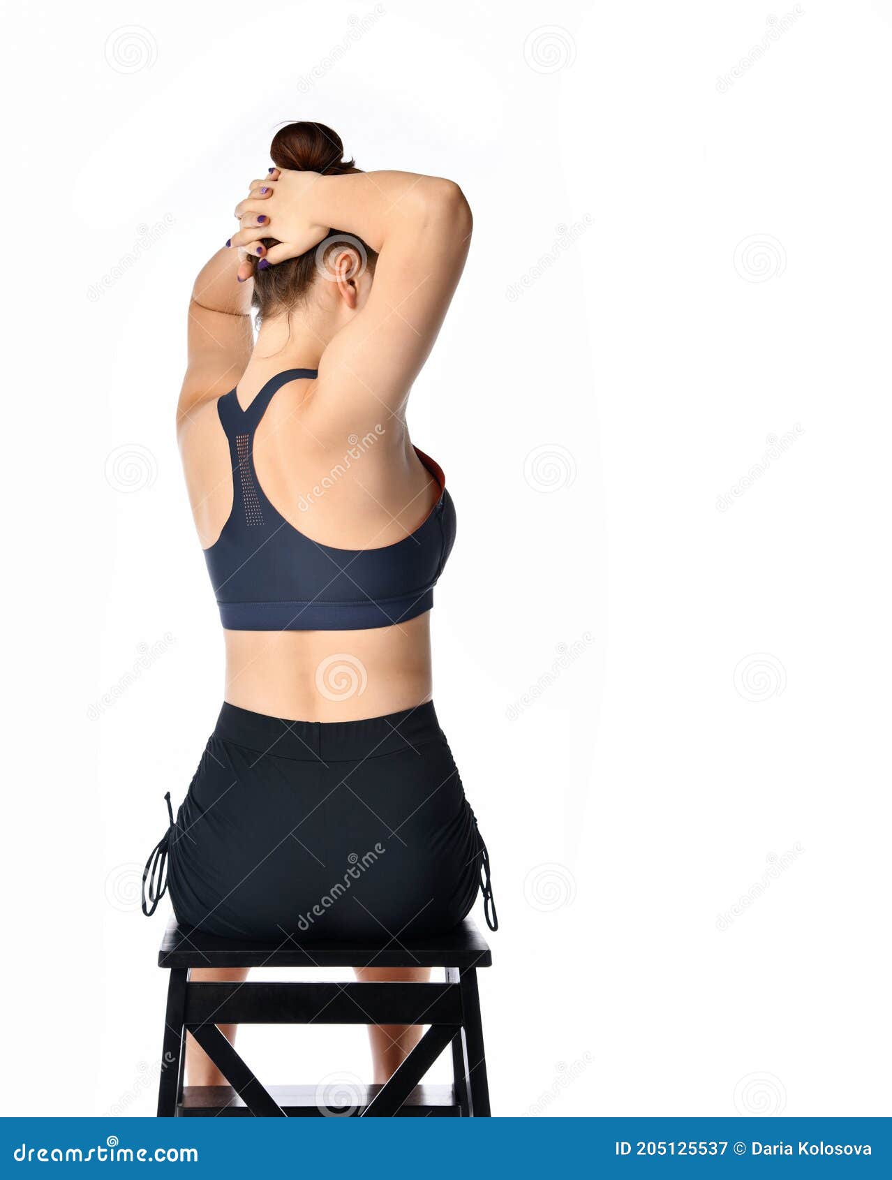 woman on chair making body twist sideway back view