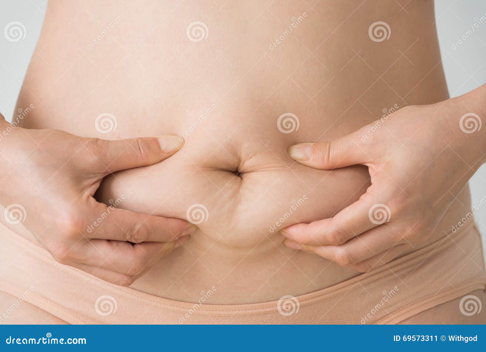 woman squeezes belly fat
