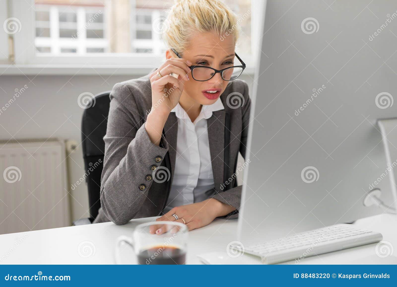 woman squeezing her eyes to see whats on computer