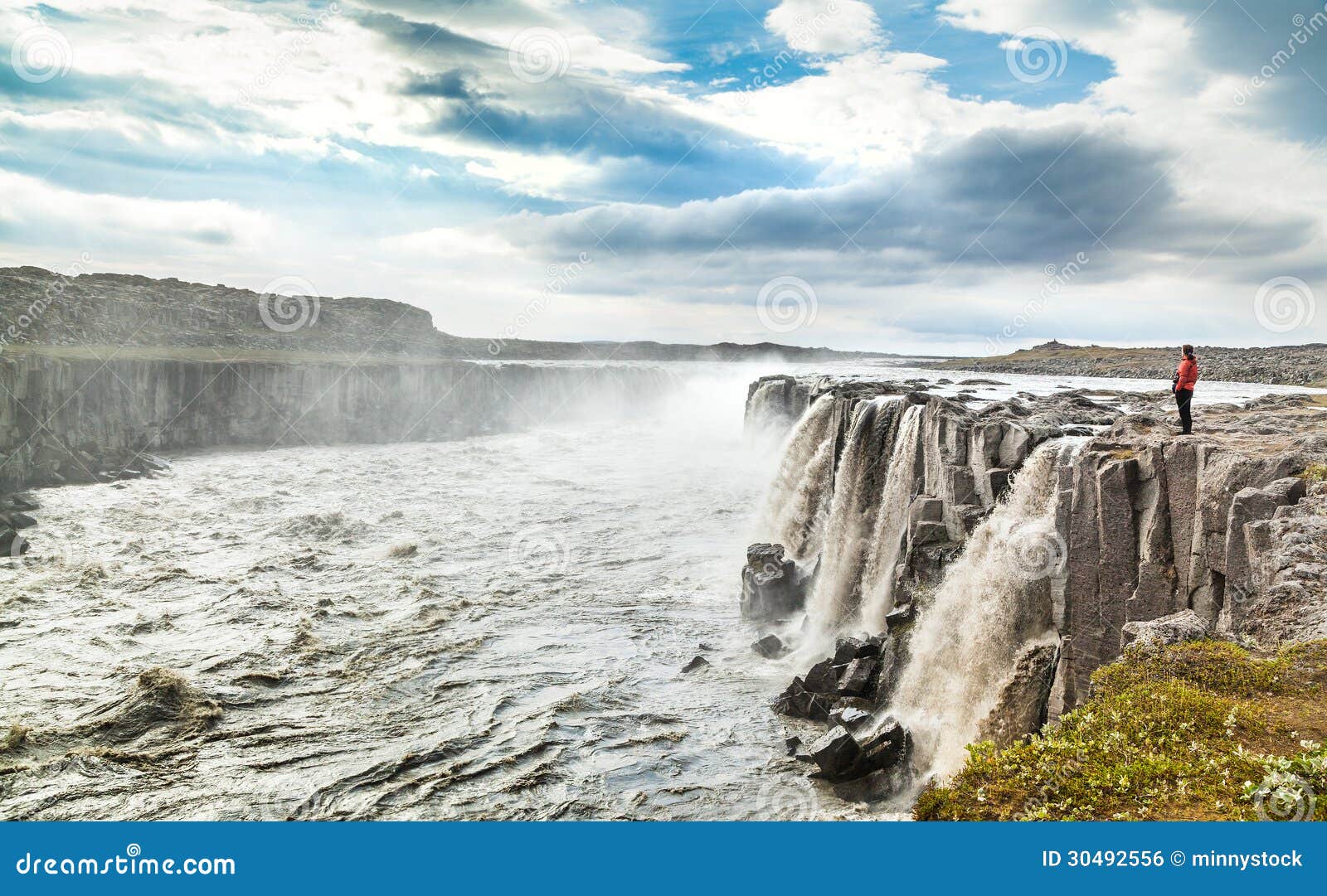 woman standing near famous selfoss waterfall in vatnajokull national park, northeast iceland