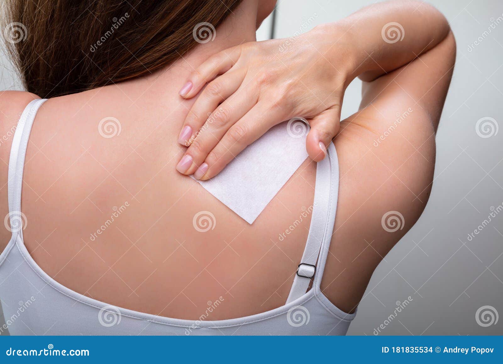 woman with stiff neck applying patch